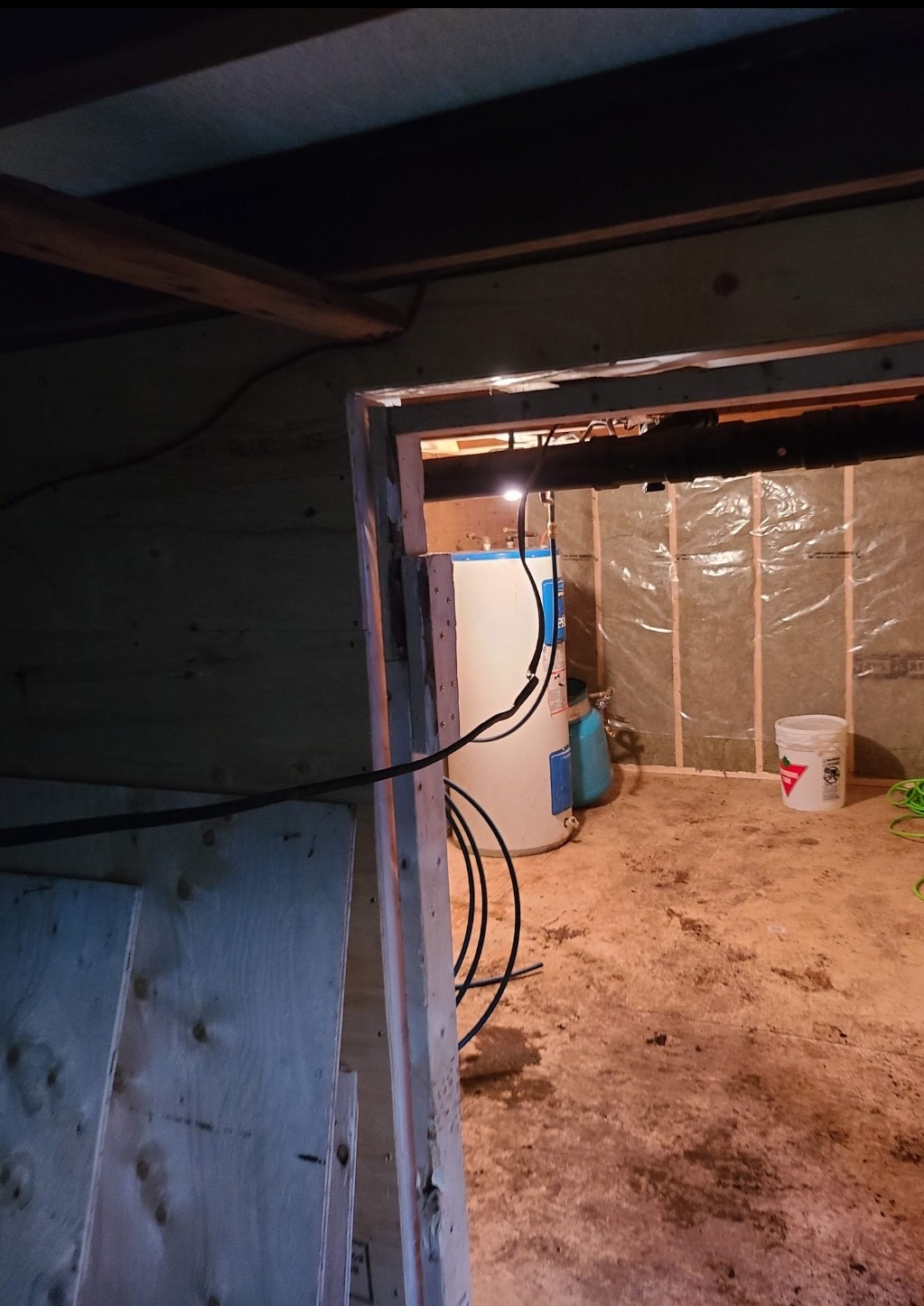 Basement renovation with steel support beam, water heater, and electrical rough-in