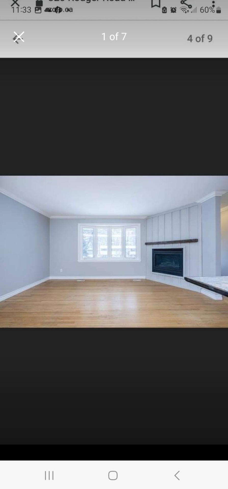 Finished living room addition with hardwood floors, bay window, crown moulding, and gas fireplace