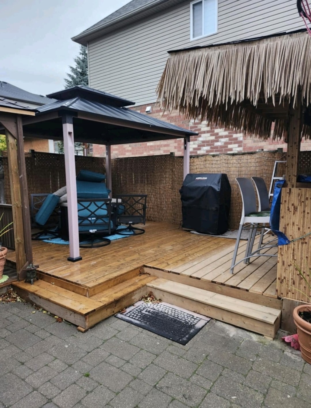 Backyard cedar deck with gazebo, tiered steps, and privacy screening