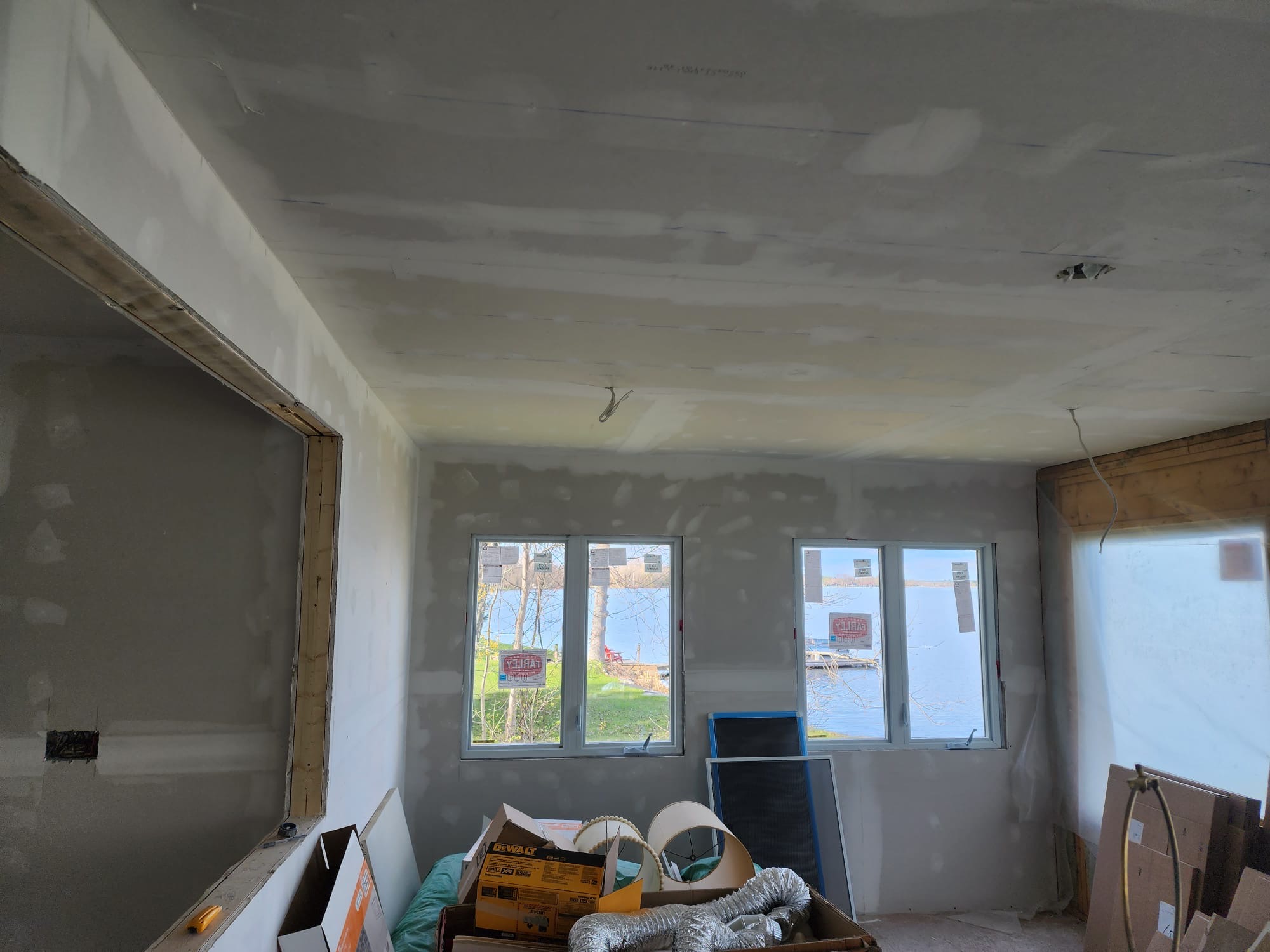 Lakeside room addition with new windows, drywall, and ceiling work in progress