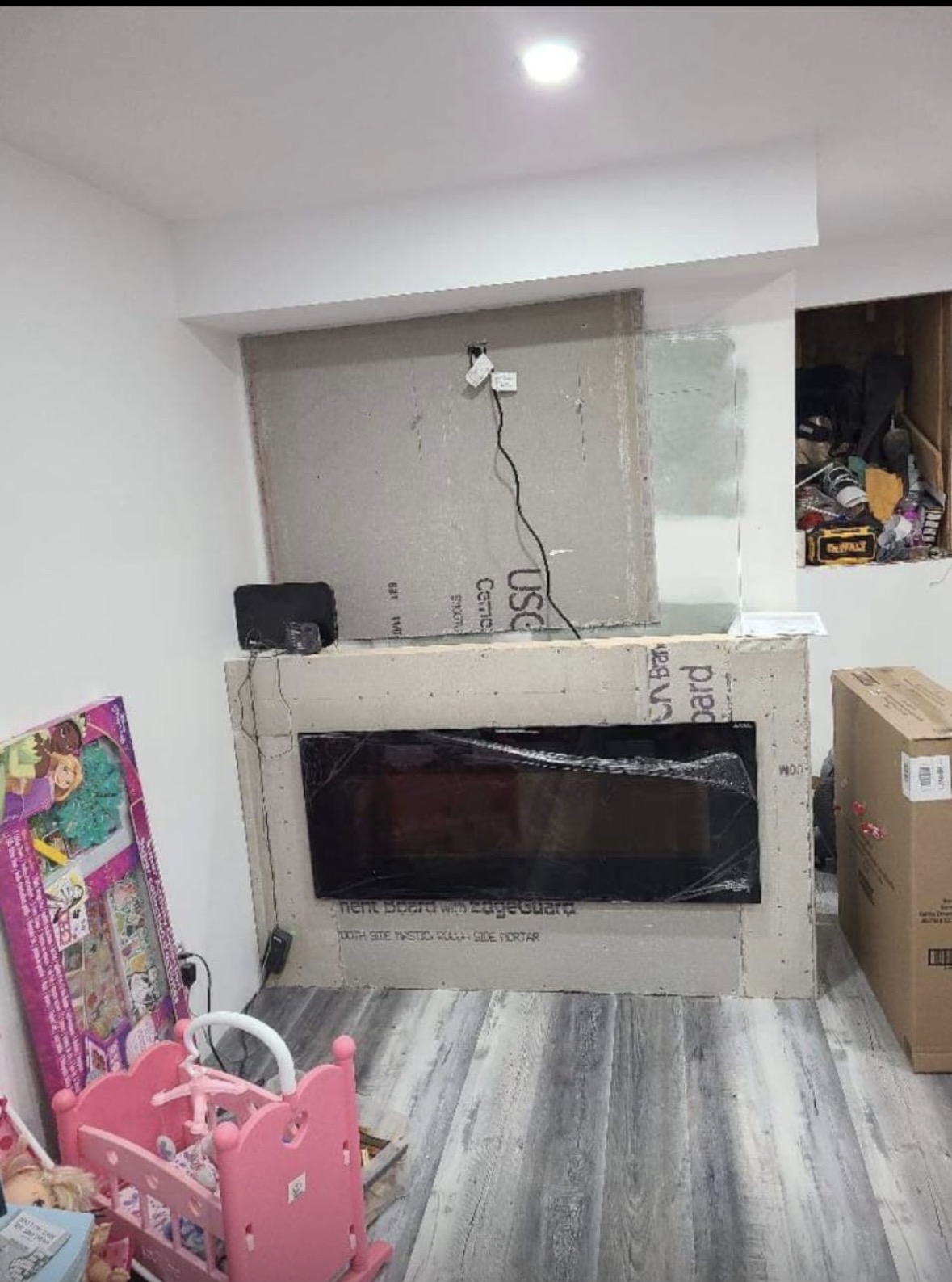 Electric fireplace installed in a cement board feature wall with wiring rough-in