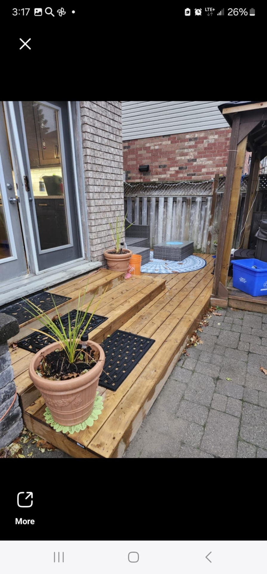 Wooden deck with built-in planter bench, steps, and patio furniture near a brick home