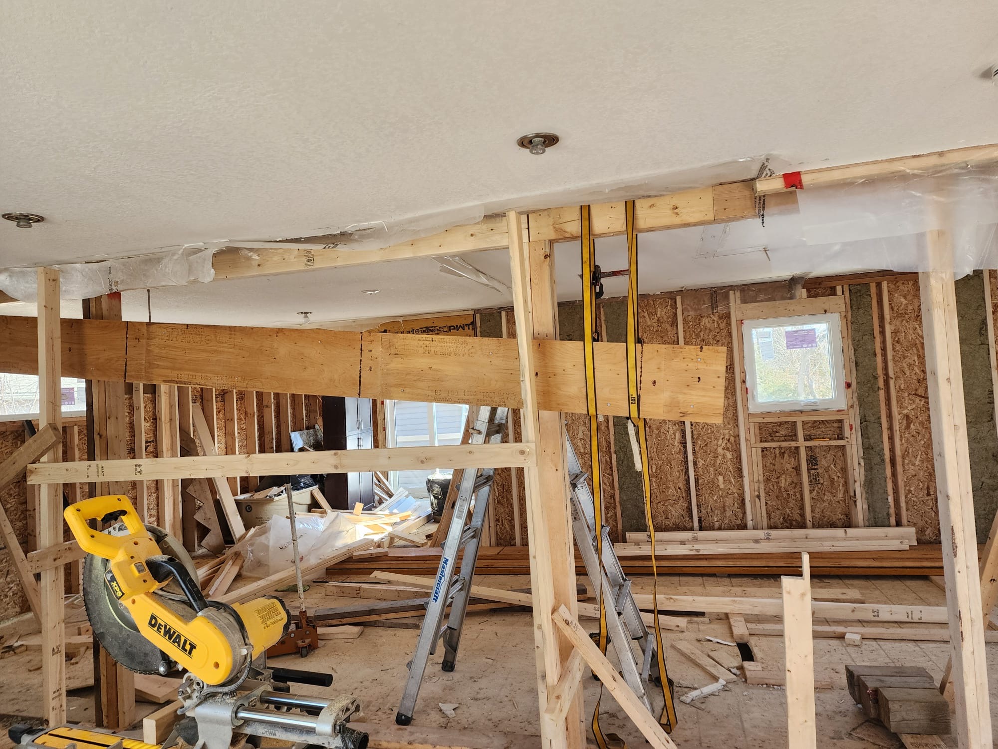 Load bearing beam installation with temporary supports and framing