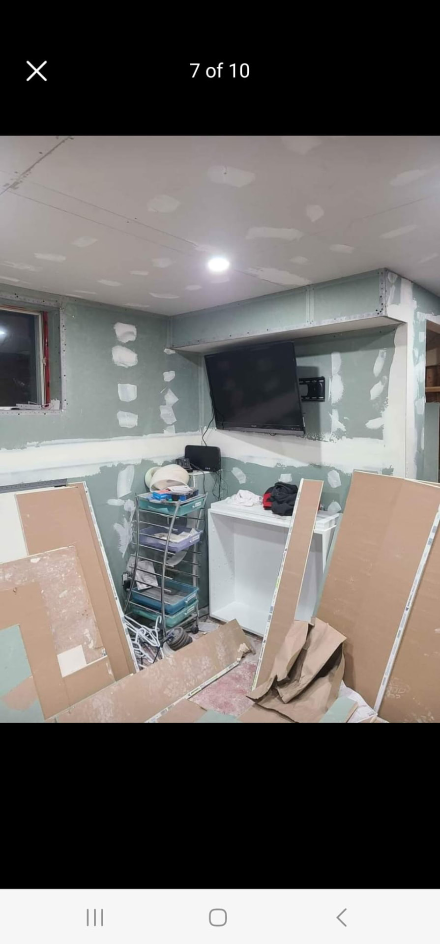 New room addition with drywall taped and mudded, bulkhead, and mounted TV