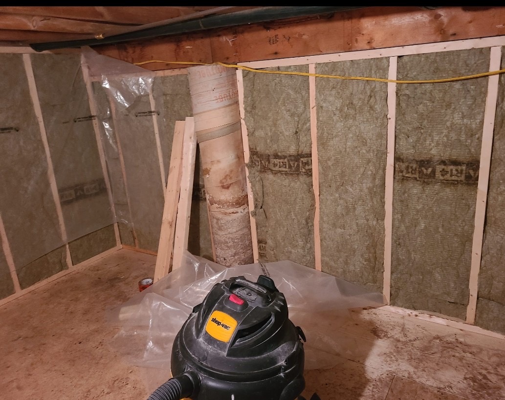 Basement wall insulation with vapour barrier and support post during renovation