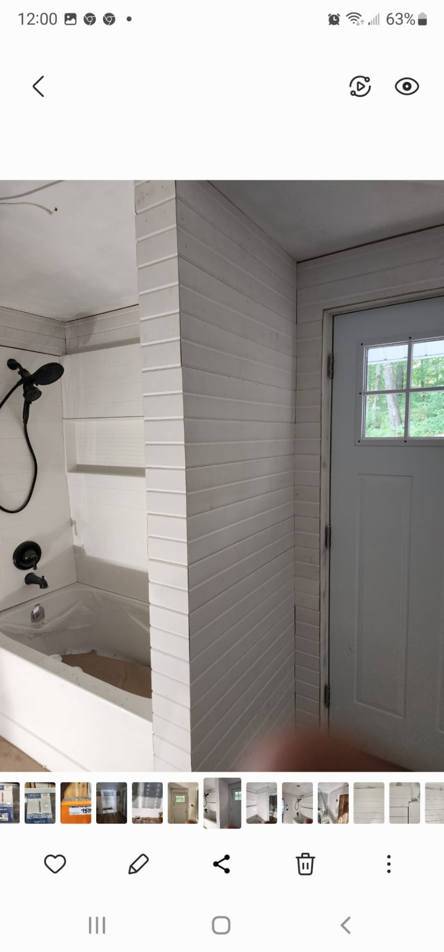 Bathroom with white shiplap tile walls, built-in tub niche, and exterior door