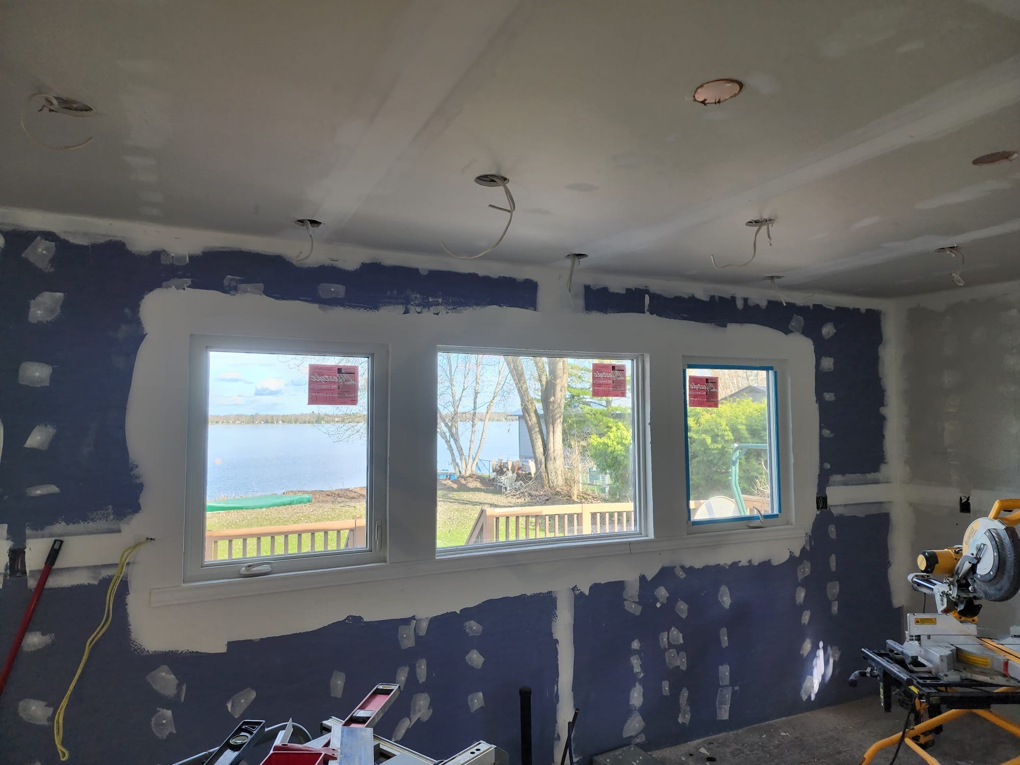Room addition drywall finishing around new lakeside windows and recessed lighting