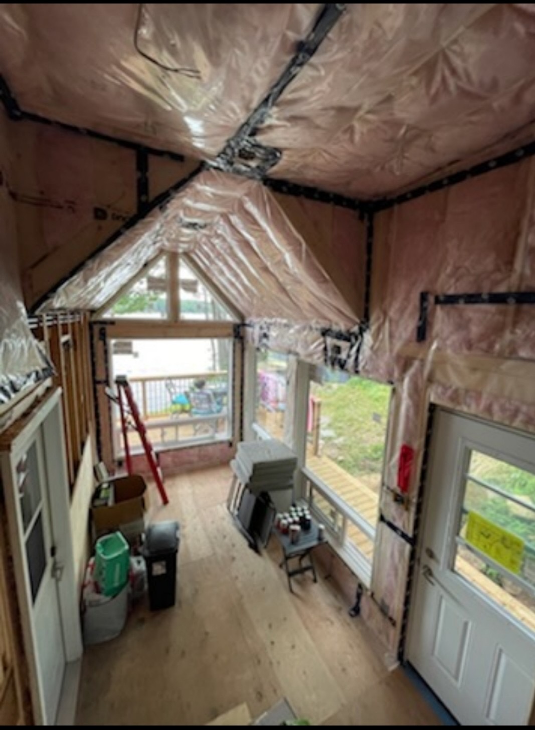 Vaulted ceiling room under construction with insulation vapour barrier and large windows