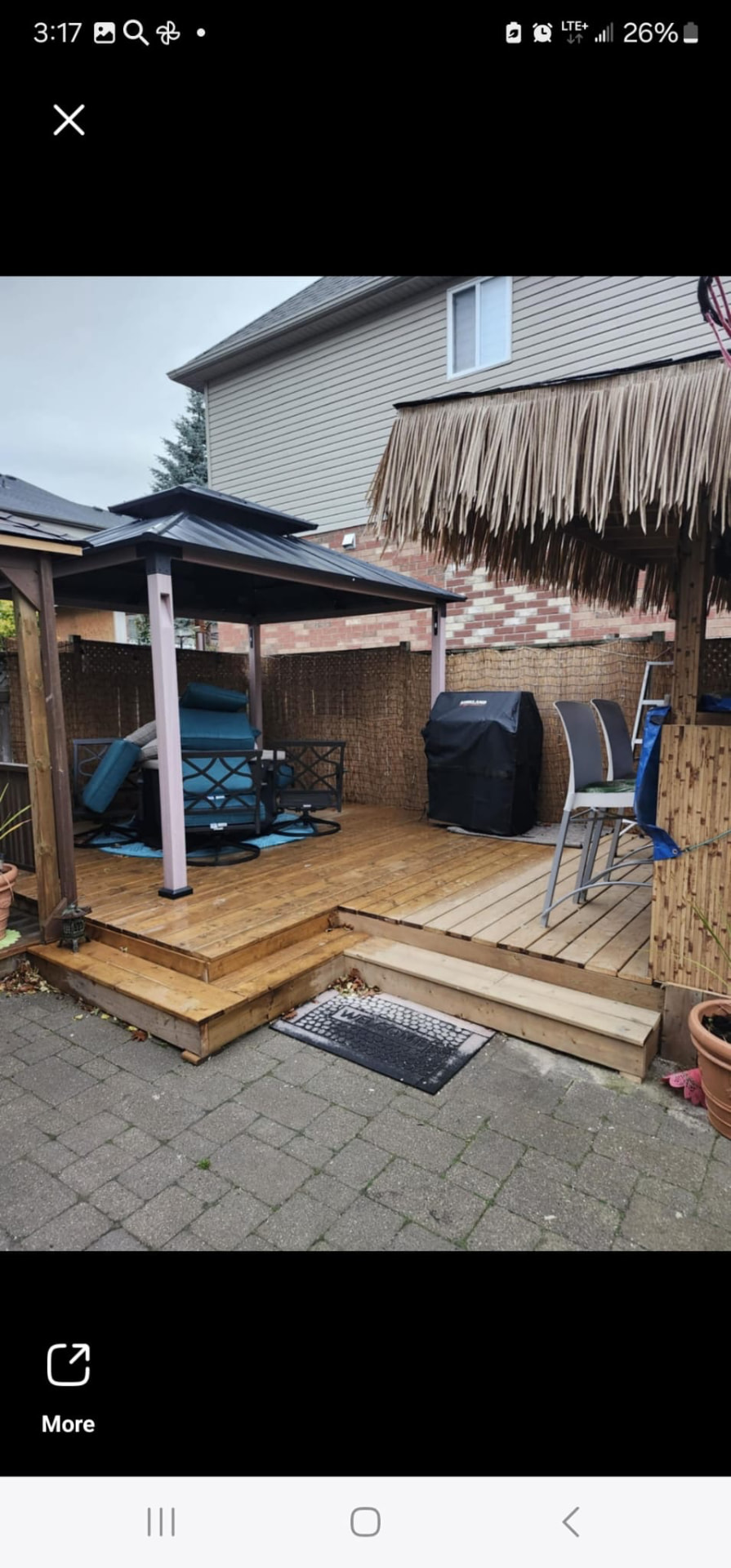 Backyard wooden deck with metal gazebo, tiki-hut lounge area, and outdoor seating