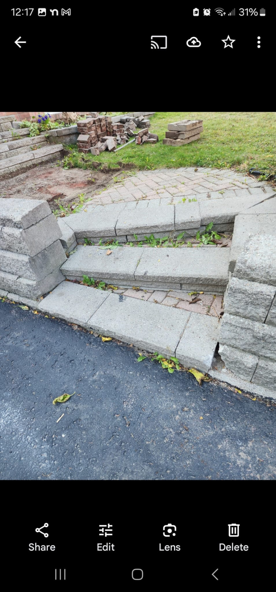 Damaged and shifted interlock stone steps and retaining wall before repair