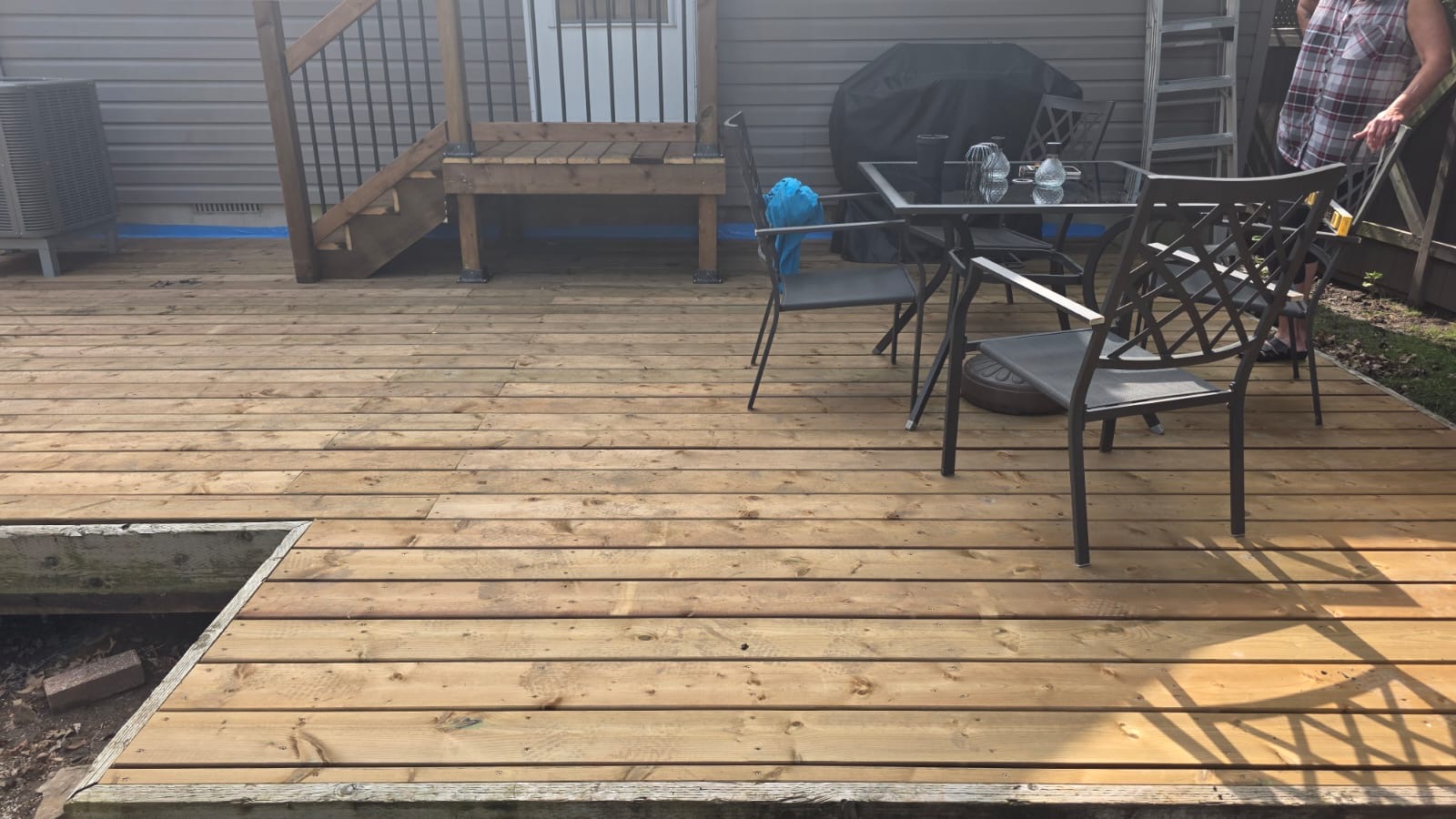 Newly built wooden deck with stairs, railing, and patio dining area