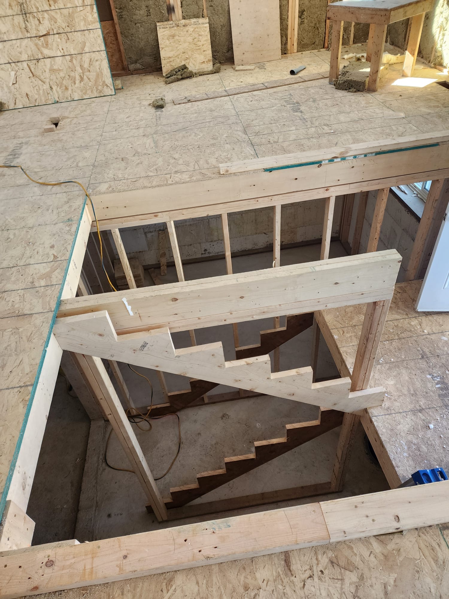 Custom wooden stair stringer and framing for a new interior staircase opening