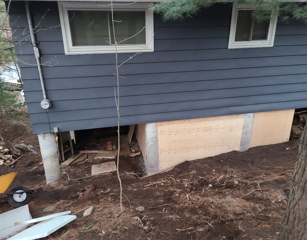 Exterior foundation and siding work with new sheathing and raised supports
