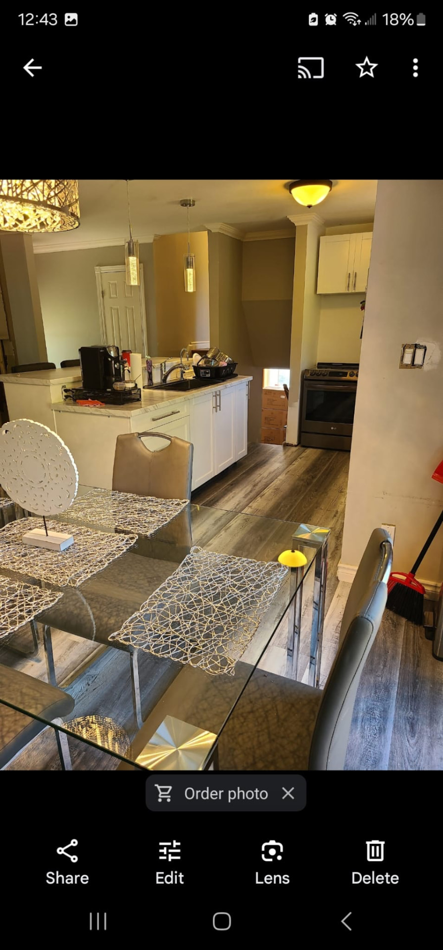 Open-concept kitchen and dining area with glass table, modern chairs, and pendant lighting