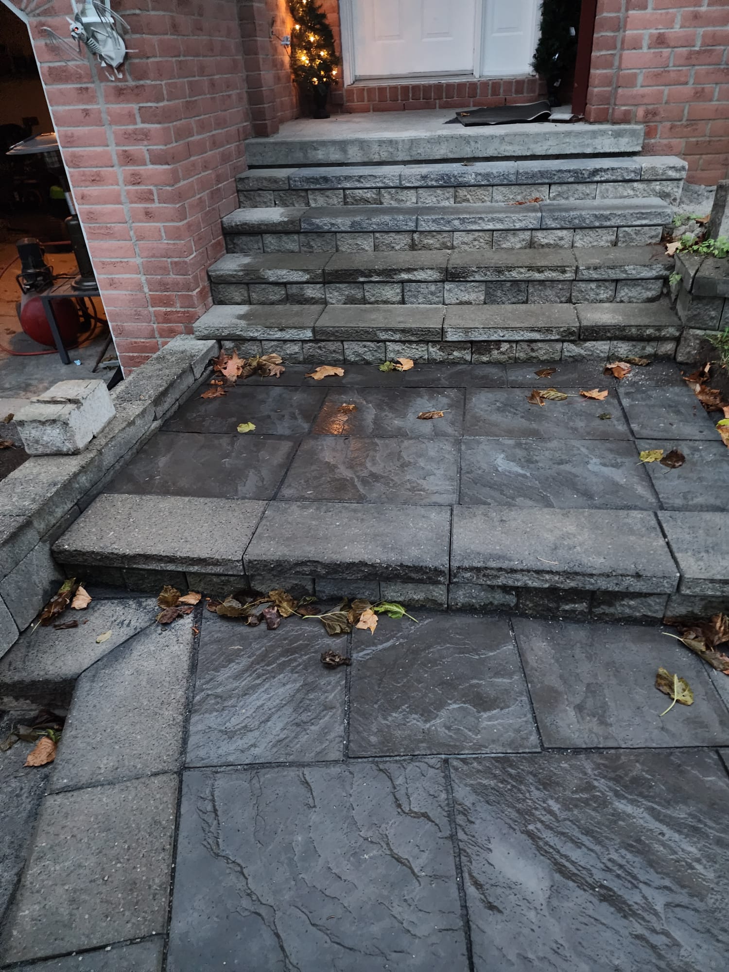 Multi-tier stone steps and landing with wet pavers and fall leaves