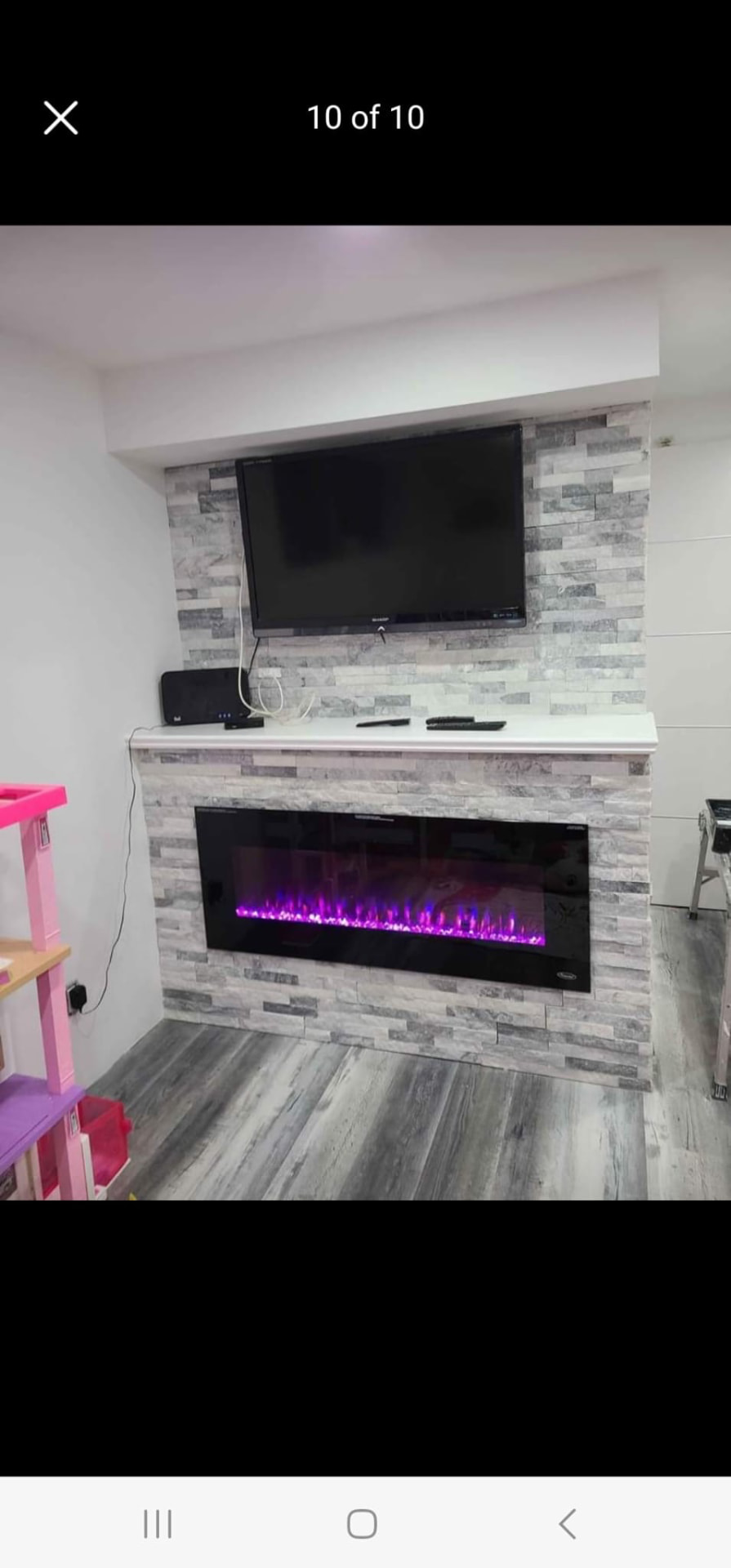 Completed basement entertainment centre with stone fireplace surround, mantel, and wall-mounted TV