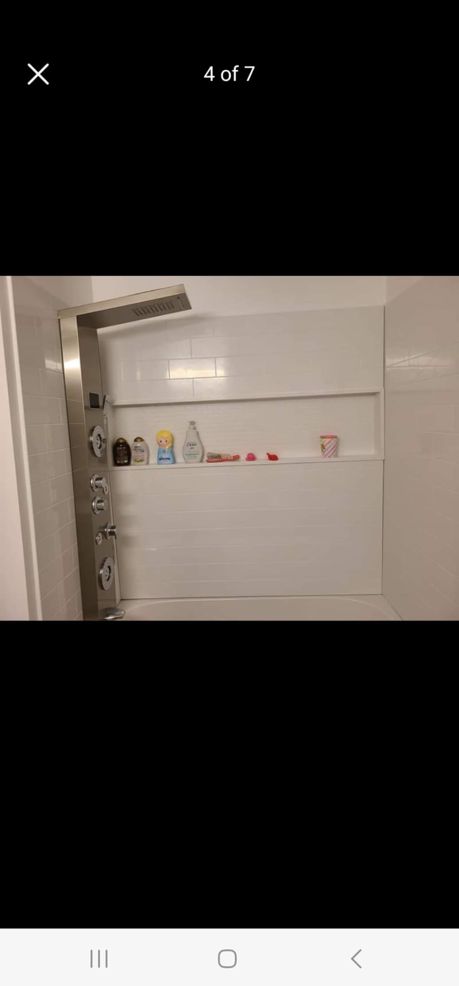 White tiled shower with built-in niche shelf and modern rainfall shower panel